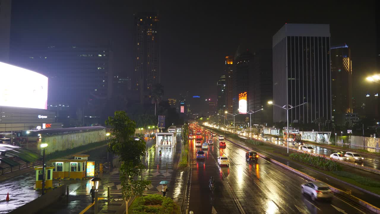 雨夜时间照明雅加达市中心交通街道道路顶部4k全景印尼视频素材