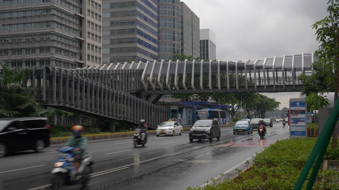 下雨天雅加达市区著名的人行天桥交通街道慢镜头全景4k印尼视频素材