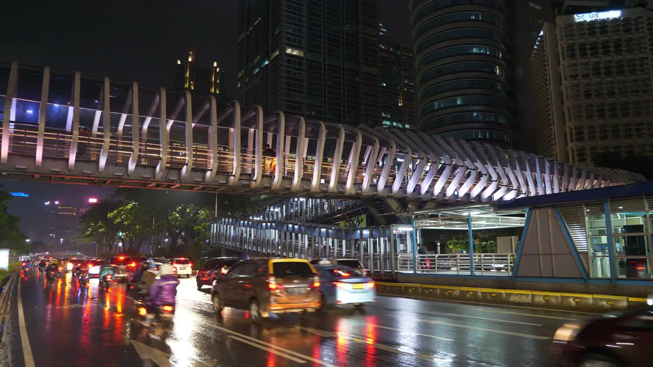 夜光雅加达市区著名的现代步行桥交通全景4k印尼街道视频素材