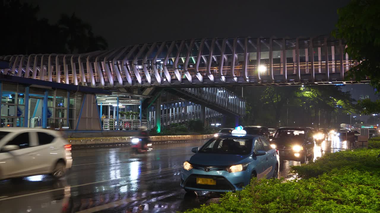 雨夜雅加达市区灯火通明，交通大街，著名的步行桥全景4k印尼视频素材