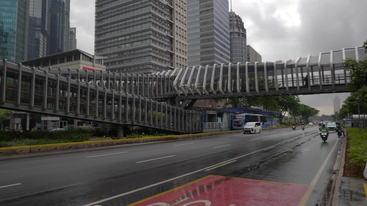 下雨天雅加达市区著名的人行天桥交通街道慢镜头全景4k印尼视频素材