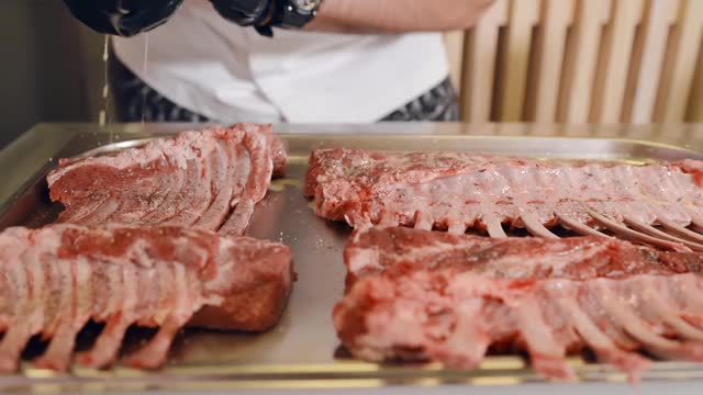 厨师将新鲜羊肉的调味料倒入腌料中。厨师把肉腌制好，准备烘烤视频素材