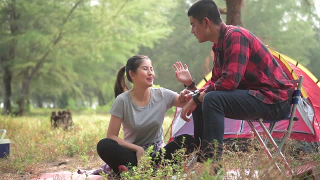 徒步旅行和露营概念。亚洲男人和女人聊天时露营在森林。视频素材