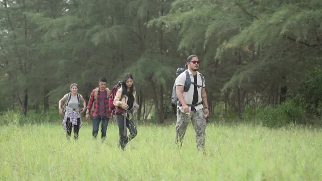 徒步旅行和露营概念。四个亚洲徒步旅行者在森林里散步。视频素材