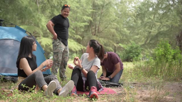 徒步旅行和露营概念。一组四个亚洲男人和女人露营和乐趣在森林。视频素材