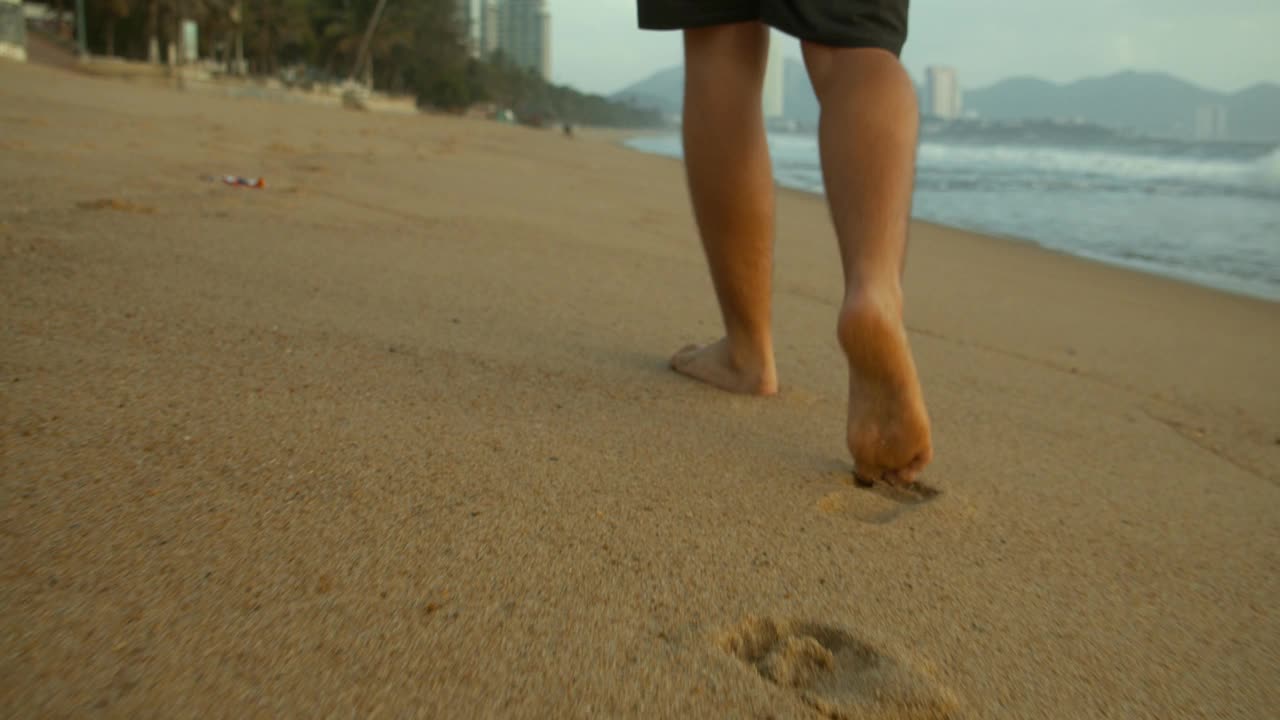 在沙滩上慢跑，夕阳西下，映衬着美丽的大海，美丽的巨浪。跑步，健康的生活方式。铁人三项运动员跑步，耐力训练，短跑。视频素材