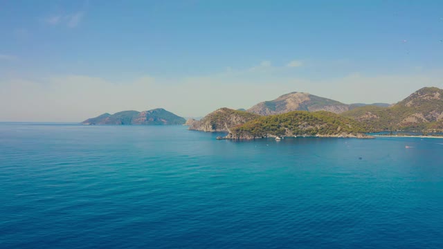 土耳其Oludeniz令人惊叹的蓝礁湖鸟瞰图。夏天的风景有山，绿色的森林，蔚蓝的水和蓝天在明媚的阳光天。鸟瞰图4 k。视频素材