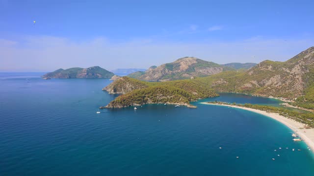 蓝礁湖的空中全景图与山脉和沙滩在Oludeniz，费特耶，土耳其。鸟瞰图4 k。视频素材