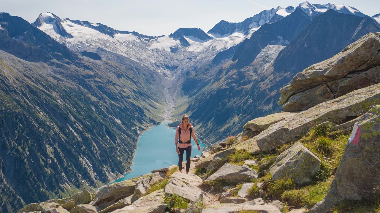 女性徒步旅行者在群山中爬山，周围是令人难以置信的风景视频素材