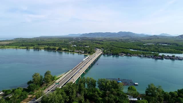 令人惊叹的鸟瞰图无人机飞过泰国普吉岛的沙罗辛大桥。这座桥连接着攀牙省。交通镜头背景和旅游季节的概念视频素材