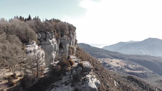 无人机拍摄的一个人走在巴塞罗那省的令人眩晕的悬崖在冬天的一天。巴塞罗那的Los acantilados del Collsacabra是一个德龙的景观。视频素材