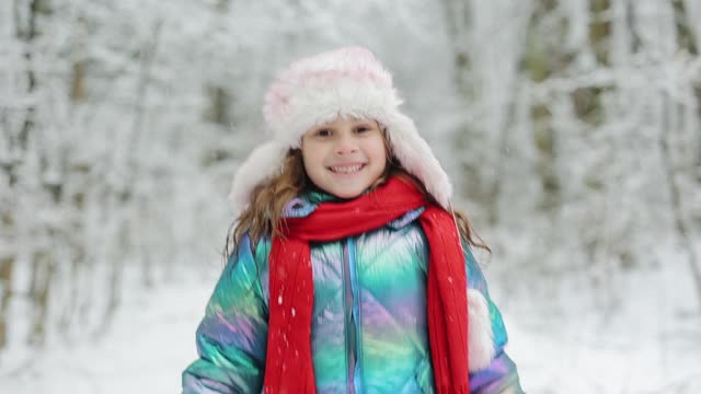 冬天森林里快乐的孩子。小女孩在雪地上跳。可爱的小女孩冬天在户外玩耍。孩子们在冬天玩得很开心视频素材