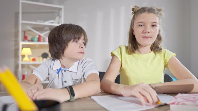 自信的白人女学生举手回答问题，像男同学一样钦佩。聪明的天才学生在学校教室学习的肖像。教育和智力。视频素材