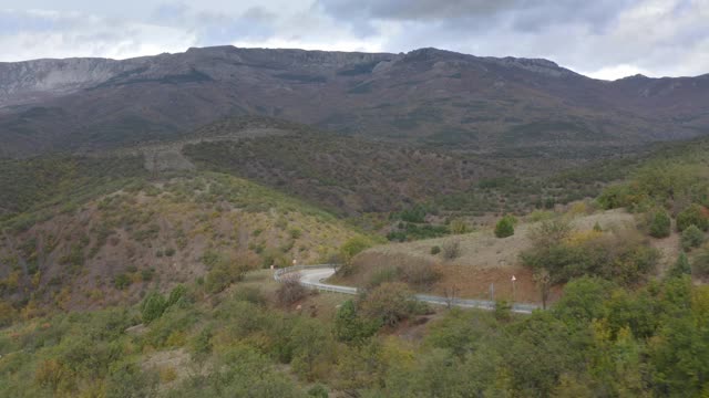 越野车在崎岖的山路上行驶。鸟瞰图的道路车辆行驶在绿色山区蜿蜒的道路上视频素材