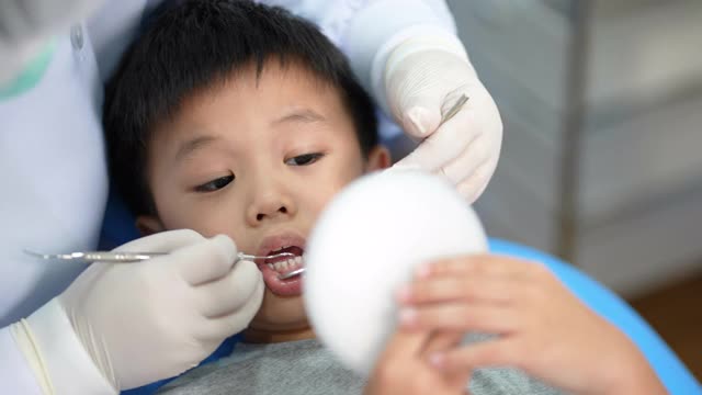 亚洲小孩在牙科诊所看牙医。牙科检查和保健的概念视频素材