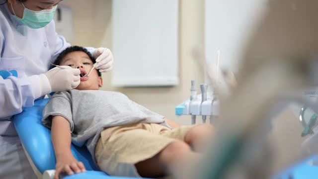 亚洲小孩在牙科诊所看牙医。牙科检查和保健的概念视频素材