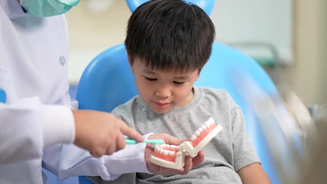 亚洲小孩在牙科诊所看牙医。牙科检查和保健的概念视频素材