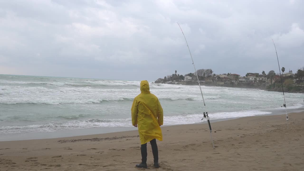 雨天在海滩上钓鱼的人。视频素材