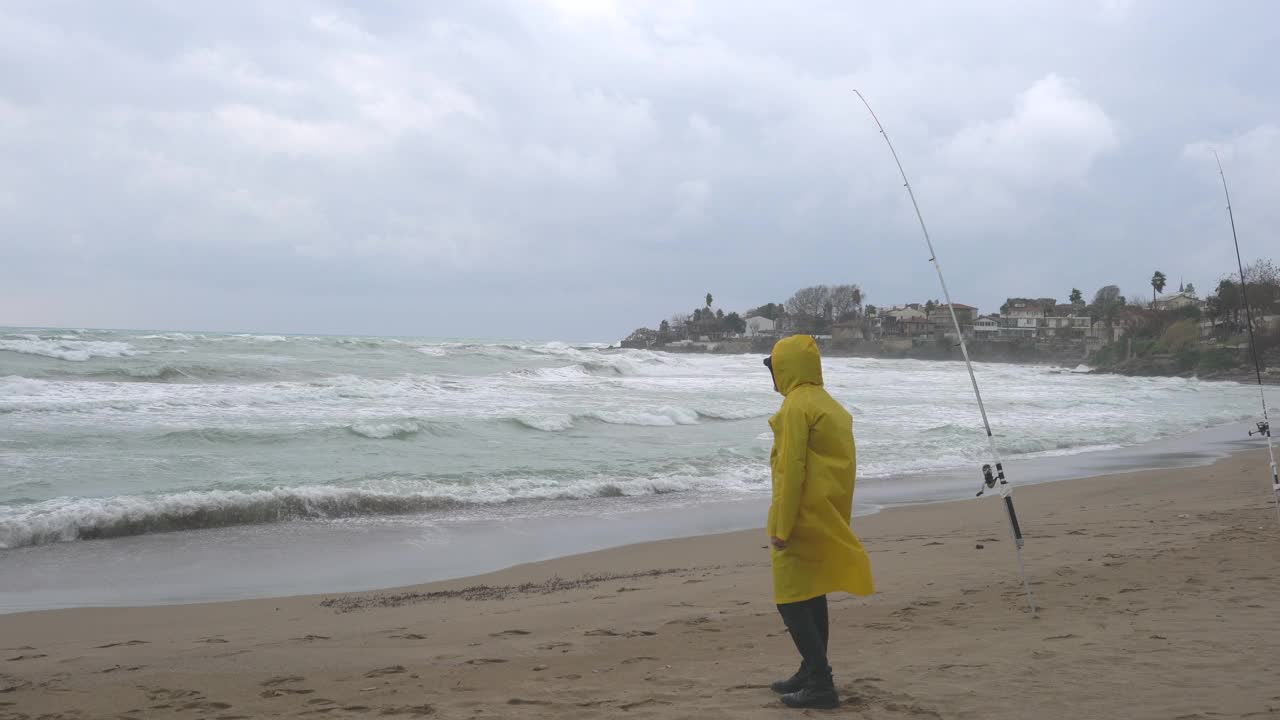 雨天在海滩上钓鱼的人。视频素材