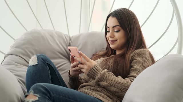 在豪华椅子上玩手机的女人视频素材