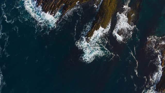 从空中俯瞰，海浪拍打着岩石。视频素材