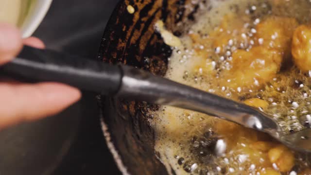 鱿鱼肉在盛满沸油的平底锅里炸。脆菜单。微距镜头。好吃但不健康。锅。视频素材