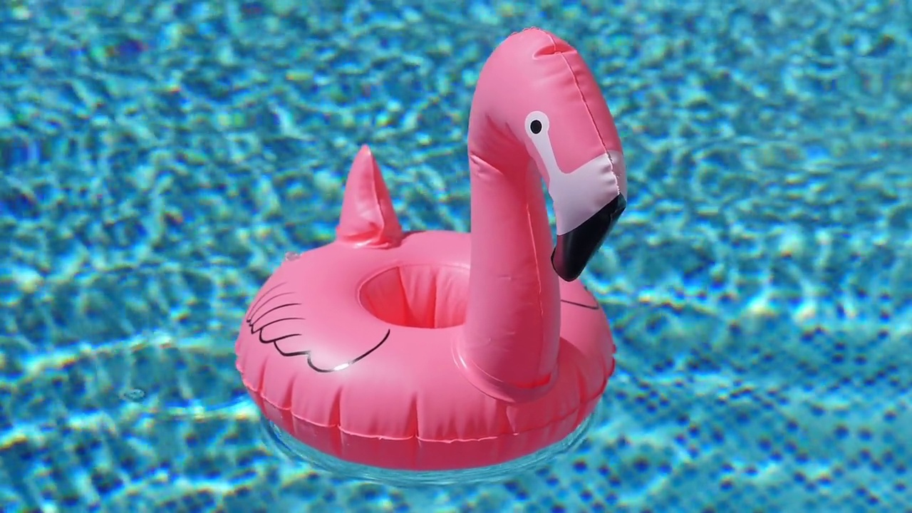 泳池边的粉红色火烈鸟充气玩具视频素材