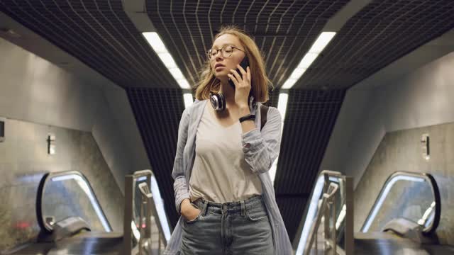 在地铁里打电话的摩登女孩。有智能手机的女孩视频下载