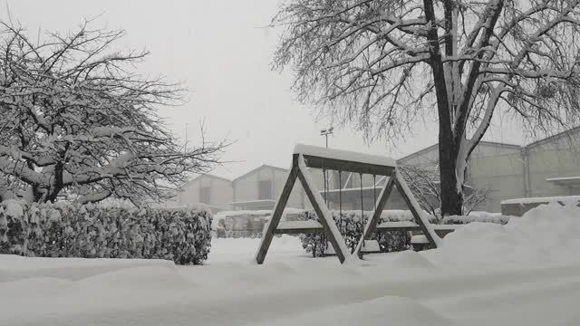 大雪在操场上荡秋千。冬天的温度很冷。视频素材