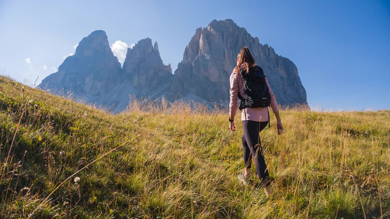 女性徒步旅行者在群山中爬山，周围是令人难以置信的风景视频素材