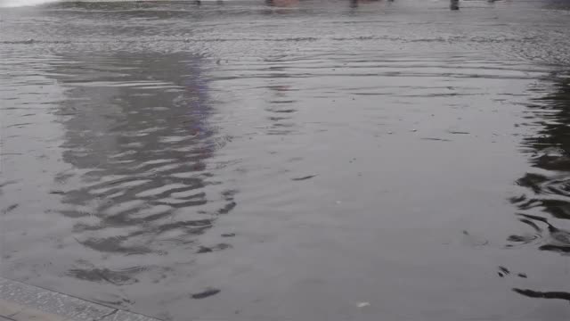 汽车车轮上的雨水在道路上的水坑在4K视频素材