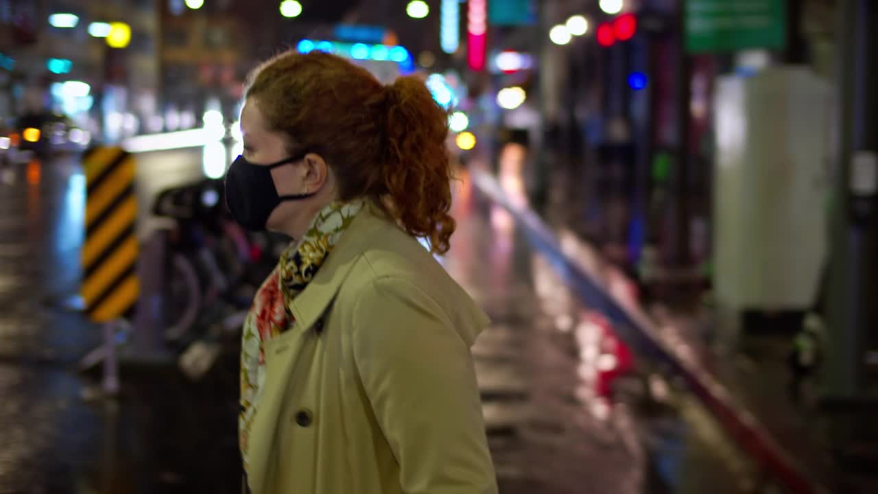 女人在雨中快速过马路的夜晚视频素材