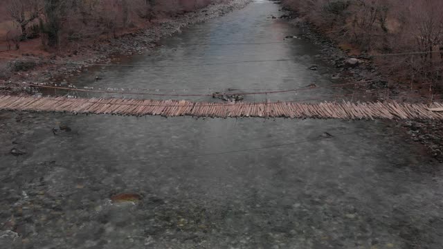 一座古老的悬索桥横跨山间河流，俯瞰一座废弃的桥，d- cinlike，没有颜色分级视频素材