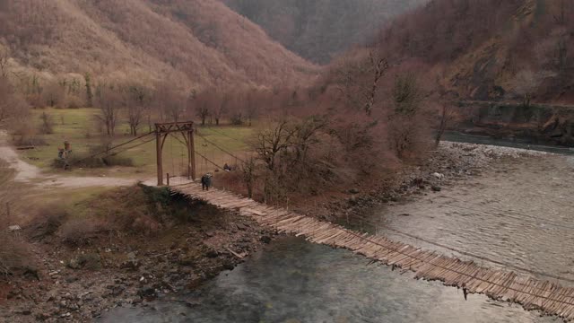 一座古老的悬索桥横跨山间河流，俯瞰一座废弃的桥，d- cinlike，没有颜色分级视频素材