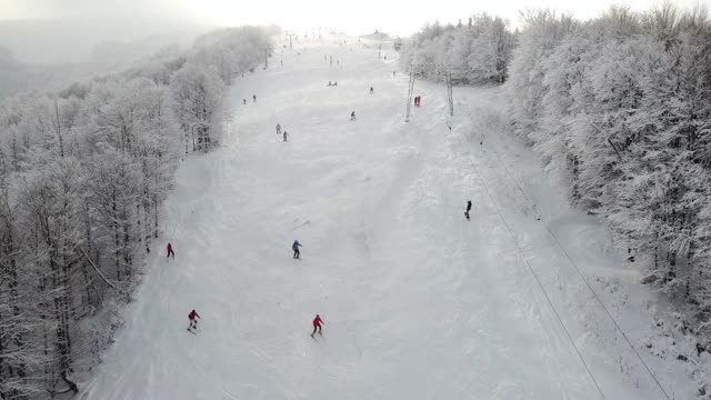 游客和度假者在山顶滑雪和单板滑雪。白雪皑皑的冬季。视频素材