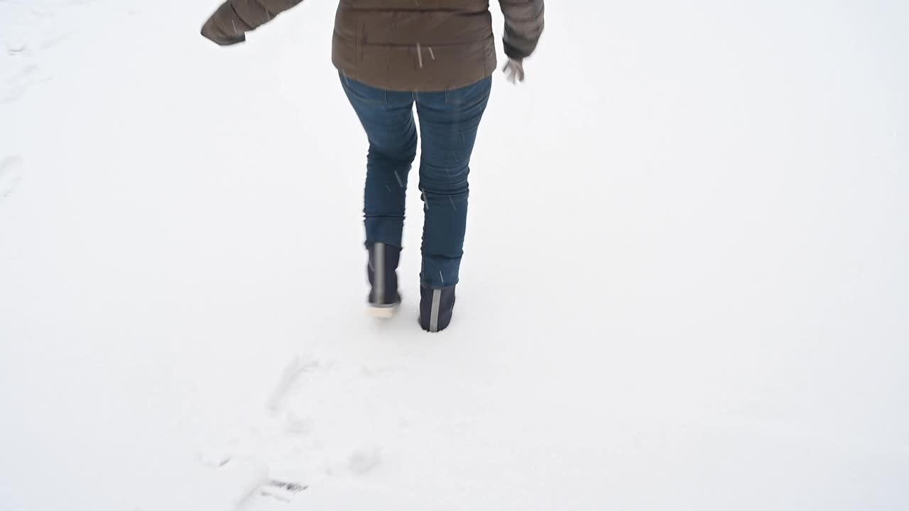 一个面目全非的女人走在雪地上。视频素材