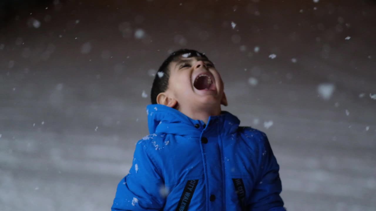 学前班的男孩晚上在雪地里玩。视频素材