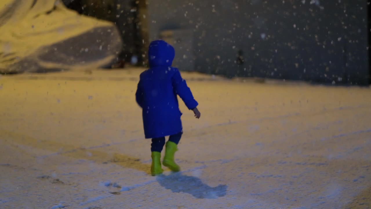 学前班的男孩晚上在雪地里玩。视频素材