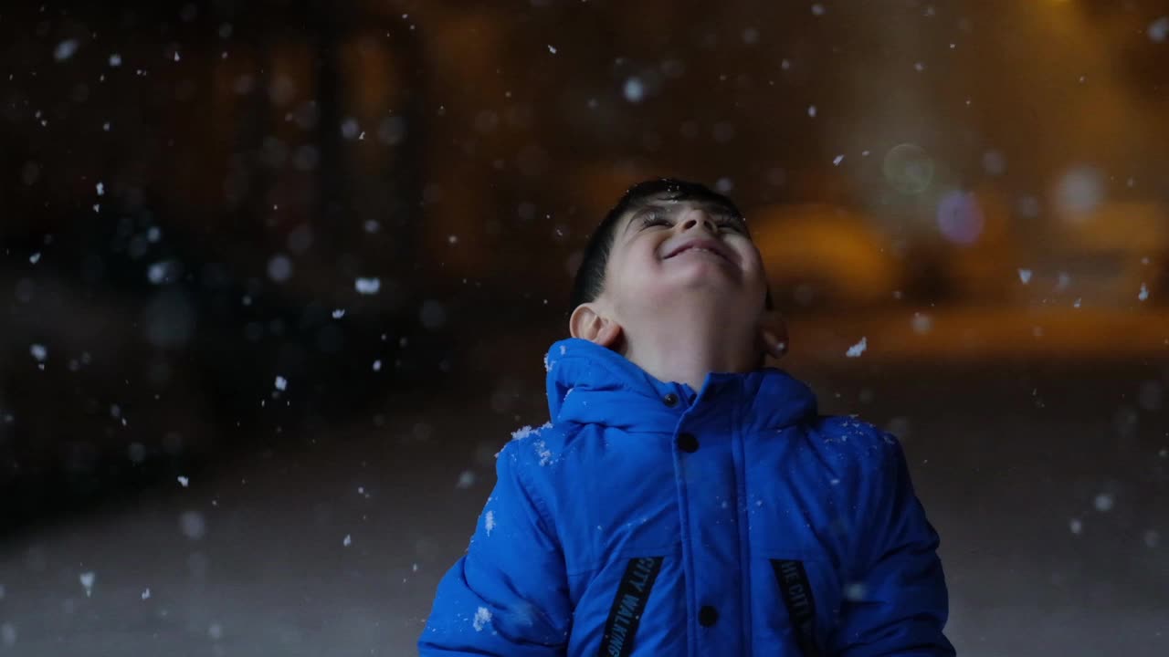 学前班的男孩晚上在雪地里玩。视频素材