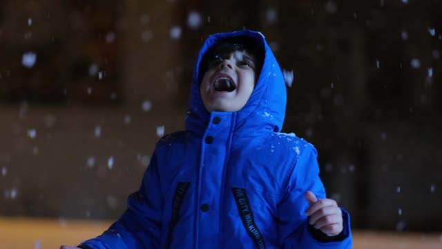 学前班的男孩晚上在雪地里玩。视频素材