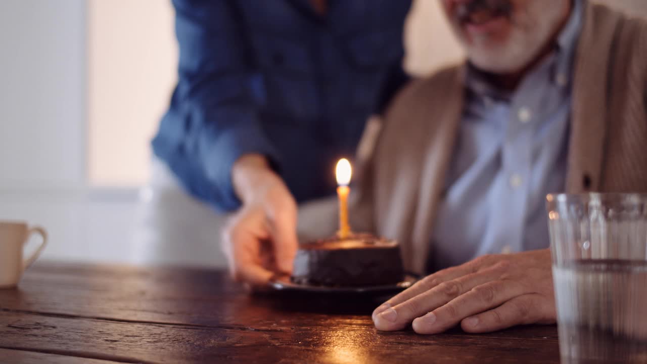 一对成年夫妇用蛋糕庆祝生日的慢镜头视频素材