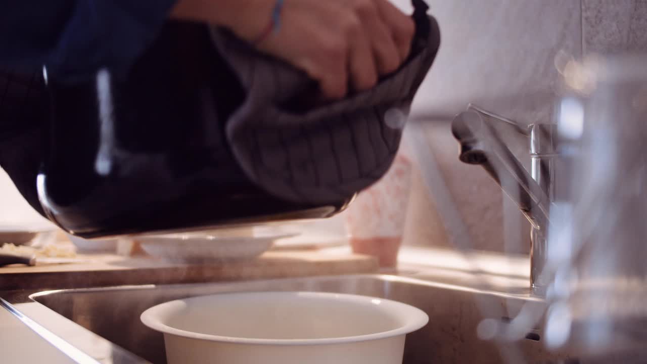 一名女子用滤水器倒饺子的慢镜头视频素材