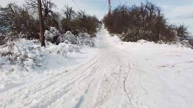 在寒冷的冬日，无人机飞过被雪覆盖的街道视频素材