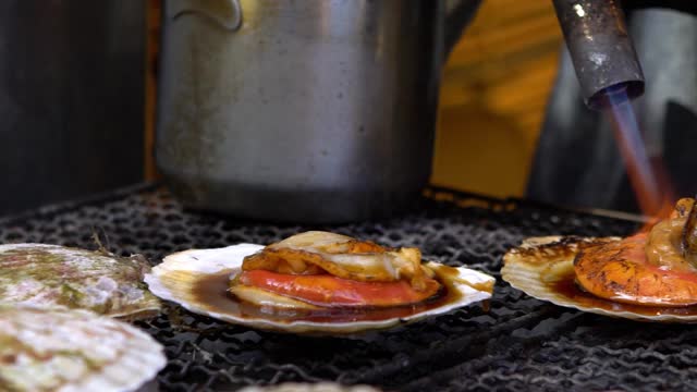 筑地外市街的慢镜头烹饪，烧鲜扇贝视频素材