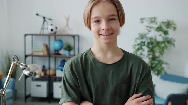 慢动作肖像的好看的少年与发式微笑看在家里的相机视频素材