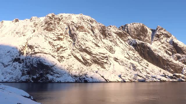 挪威罗浮敦的海滩和雪山景色令人惊叹。冬天的风景视频下载