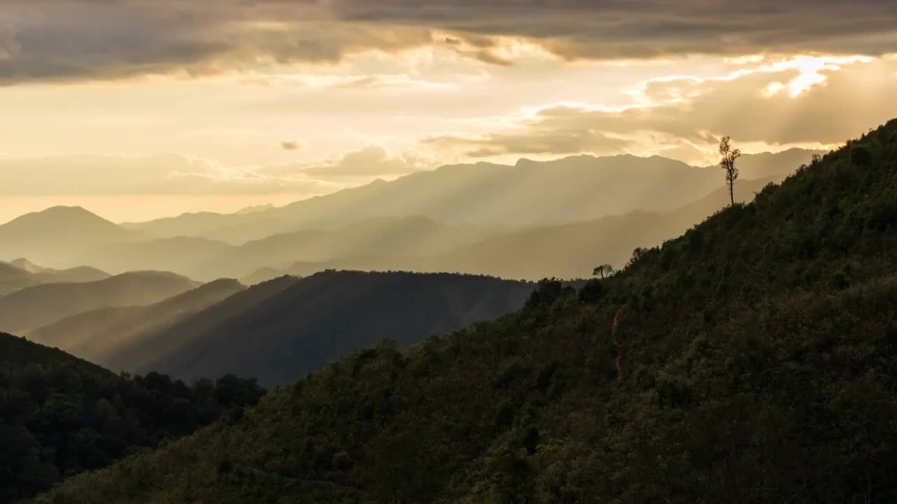 在泰国南怀Thon村，阳光透过云层出现在山景中的时间流逝视图。镜头时间推移的自然景观和戏剧性的彩色天空。视频素材