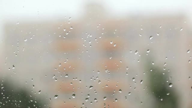 焦点从玻璃上拿着雨滴落到建筑物上视频素材