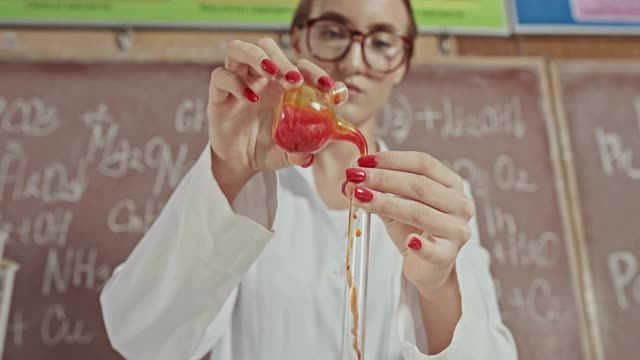 潘左低角度拍摄了一个专门的化学家混合化学物质在试管在实验室创新工作-近距离视频素材