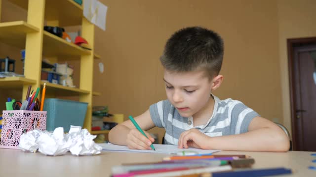 一个学龄男孩在家做家庭作业。在学校培训视频素材